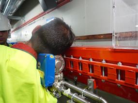 Eric resting his head on a booster bending magnet